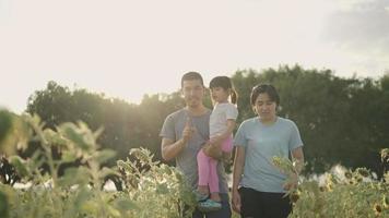 een Aziatische vader nam zijn dochter graag mee naar het zonnebloemveld. tijdens de zonsondergang video