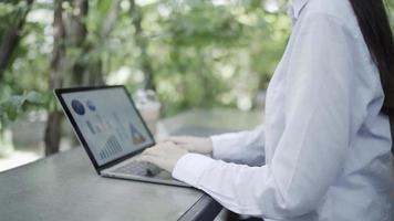 mujer desarrollando un proyecto empresarial y analizando información de datos de mercado en una computadora portátil en la oficina exterior