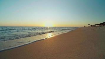 zonsondergang op het strand, stralende gouden golven video