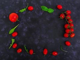 tomates cherry maduros frescos y pimienta sobre un fondo oscuro. vista superior foto