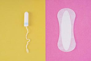 cuidado de la higiene durante los días críticos. elegir entre un tampón y una toalla sanitaria. ciclo menstrual. productos de higiene para la mujer. vista superior foto