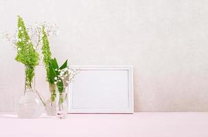 Flowers and plants in flask with frame. Beautiful spring background with flowers in vase. photo