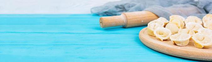 Homemade raw dumplings, pelmeni, on wooden background. Banner. photo