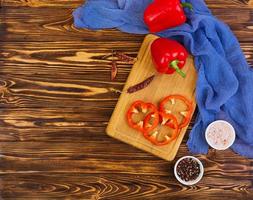 Pepper, tomato, salt, different spice on wooden background photo