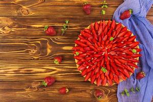 Delicious tart with strawberry on wooden background photo