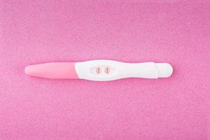 Positive pregnancy test isolated on pink background photo