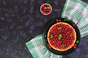 Delicious tart with custard and raspberry on wooden background photo