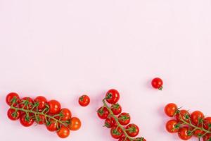 Isolated fresh red cherry tomatoes on pink background. Top view. Flat lay photo