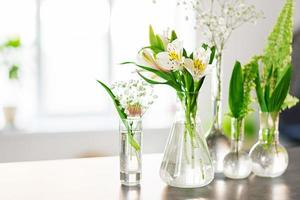 Beautiful spring flowers in a vases on light background photo