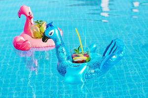 Fresh coctail mojito on inflatable toy at swimming pool. Vacation concept. photo