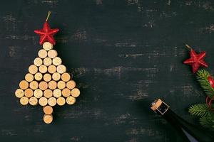 New Year decoration with christmas tree made of wine corks and bottle of champagne. Christmas background. Top view.