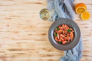 Fried shrimps with spicy orange sauce on wooden background photo