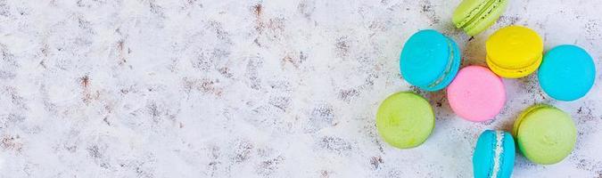 Delicious colorful macaron cakes on white background. Top view. Banner. photo