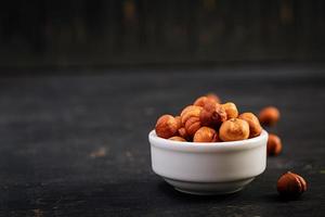 Hazelnuts on dark wooden background. A handful of nuts. photo