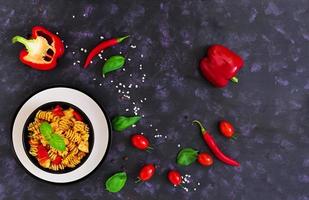 Radiatori pasta with chicken and peppers on dark background. Top view