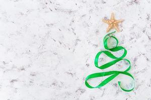 Christmas tree made of ribbon and starfish on white background. Top view photo