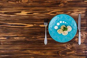 Delicious homemade dumplings, pelmeni, on wooden background photo