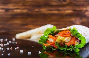 Delicious shawarma sandwich on wooden background photo