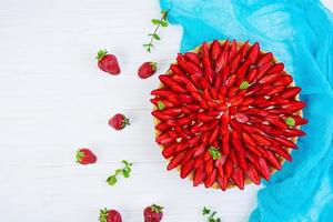 Delicious tart with strawberry on wooden background photo