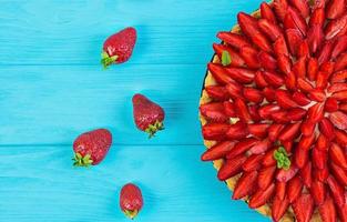 Delicious tart with strawberry on wooden background photo