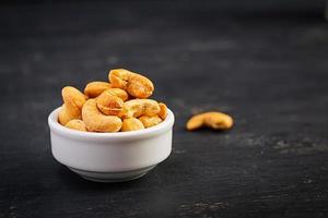 Cashews on dark wooden background. A handful of nuts.