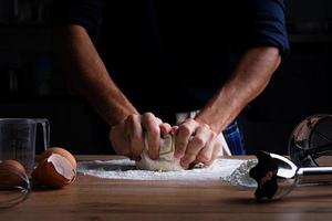 Male hands making dough for pizza, dumplings or bread. Baking concept.