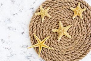 Rope and starfish on white background. Top view