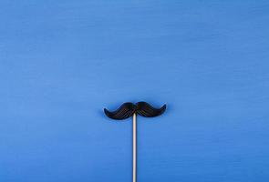 Fake black mustaches in stick. Happy Fathers day. Background of fathers day. Top view. Flat lay. photo