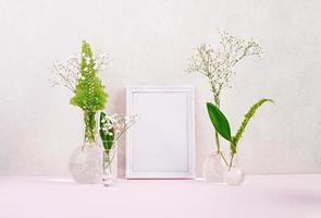 Flowers and plants in flask with frame. Beautiful spring background with flowers in vase. photo