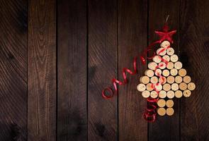 Christmas tree made of wine corks on wooden background. Mockup postcard with Christmas tree and copy space for text. Top view. photo
