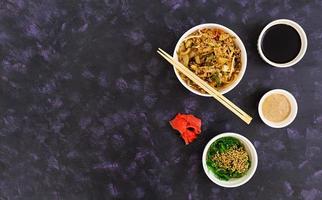 Udon noodles with seafood on dark background. Top view. photo