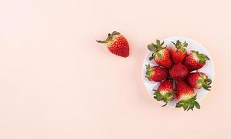 Sweet strawberry on pink background. Top view. Flat lay. photo