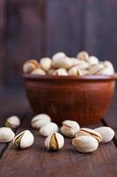 Pistachio nuts on wooden background. Roasted salted pistachios. photo