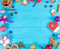 Christmas background. Christmas gift, toys, gingerbread cookies, spices and decorations on wooden background. Top view photo