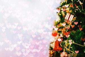 Close-up gift box on Christmas tree with abstract bokeh light background. photo