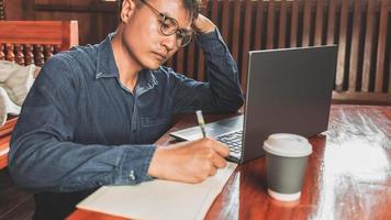 teleconferencia de hombre de negocios desde casa hombre de negocios en una reunión usando su computadora portátil y escribiendo notas foto