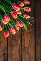 A bouquet of tulips lies on a brown wooden background photo