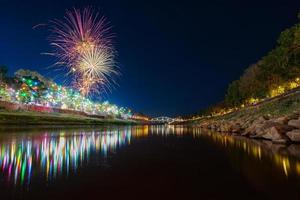 fuegos artificiales en el paseo marítimo con luces en phitsanulok, tailandia. foto