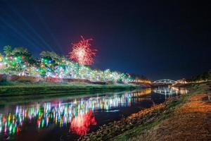 fuegos artificiales en el paseo marítimo con luces en phitsanulok, tailandia. foto