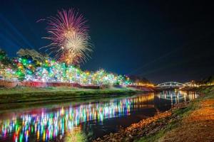 fuegos artificiales en el paseo marítimo con luces en phitsanulok, tailandia. foto