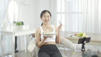 Female blogger leads online course on healthy eating, talking in front camera on social networks. Fitness woman records training on vegetarian cooking Distances diet through smartphone video tutorial