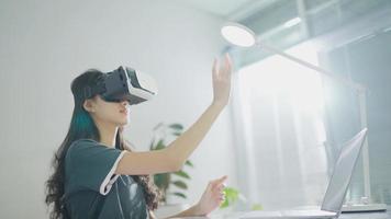 Slow-motion.Woman exploring cyberspace with virtual reality headset. Young female in VR goggles experiencing virtual world and following invisible object at home video