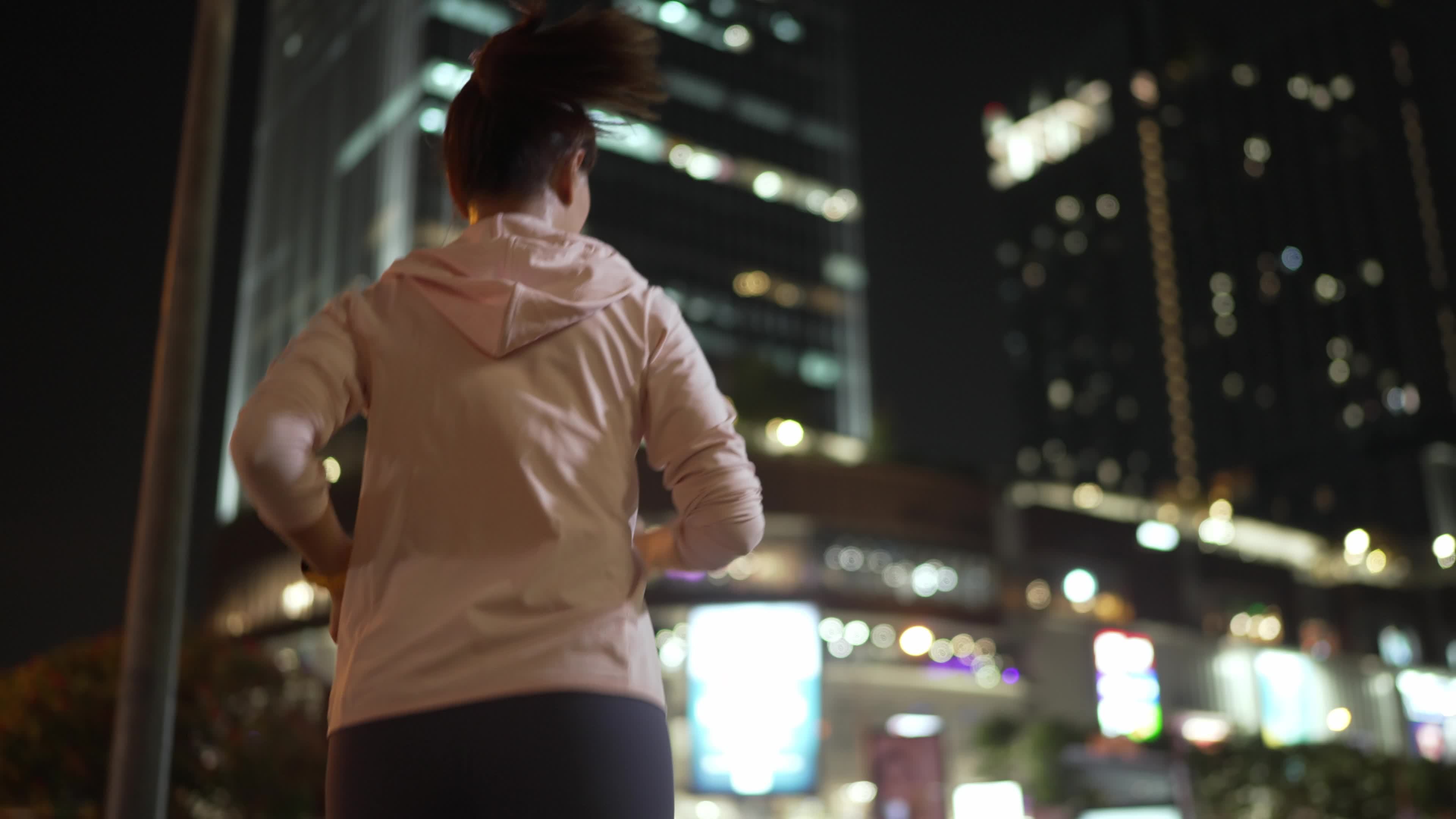 Closeup,Slowmotion,Back Follow Camera View.Female athlete in hooded