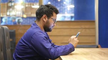 side view of young man using smart phone at cafe video