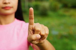 mujer asiática señalando con el dedo hacia adelante foto