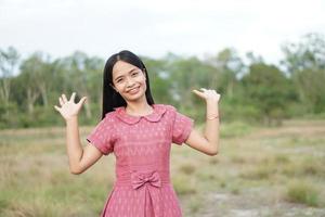 Asian woman smiling happily raise your hand to the sky nature background photo