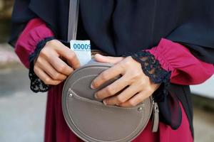 Woman takes banknotes from her sling bag photo