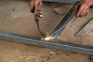 A male welder is making a steel frame construction