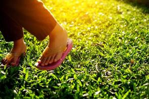 parte del pie de una niña en el parque bajo el cálido sol de la tarde foto