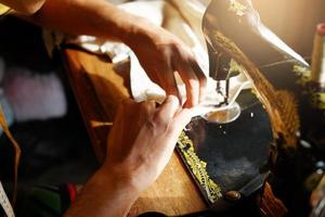 A man is sewing a customer's order photo